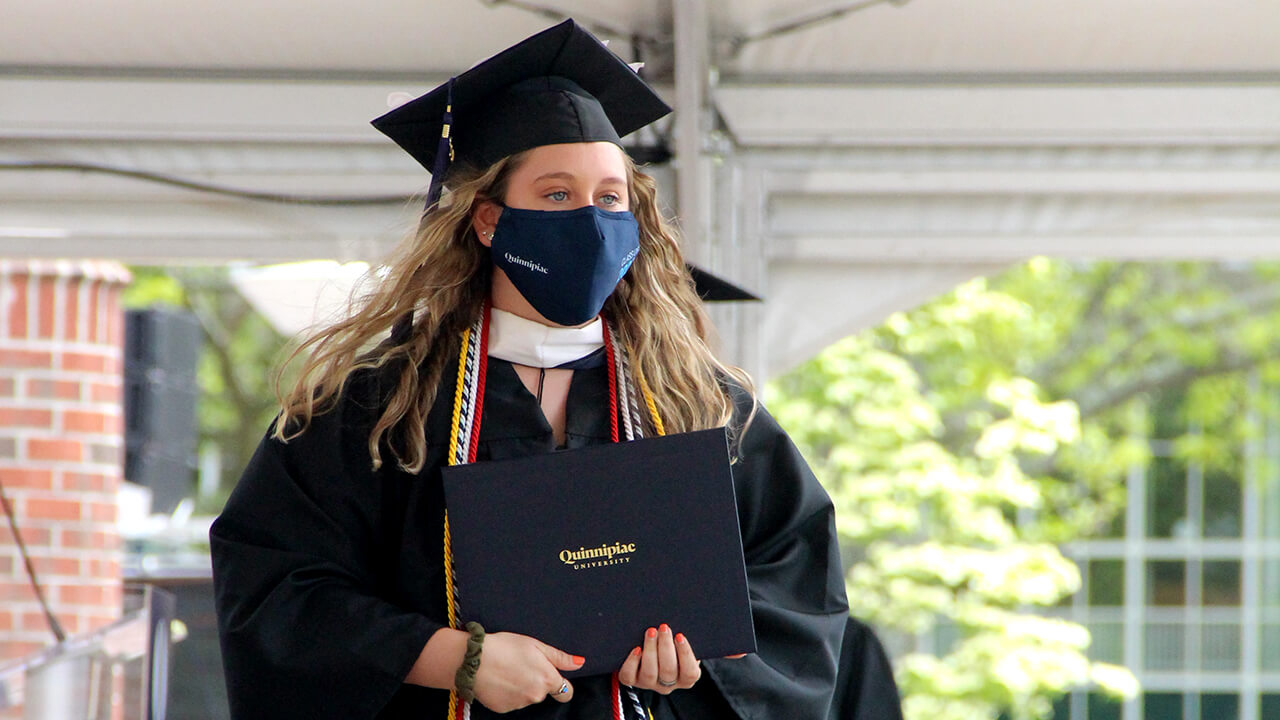 Graduate walking across the stage with her diploma
