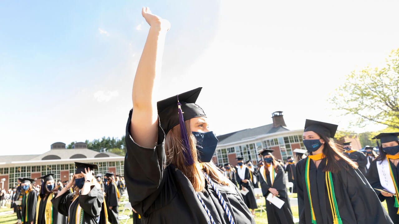 Graduate waving at family