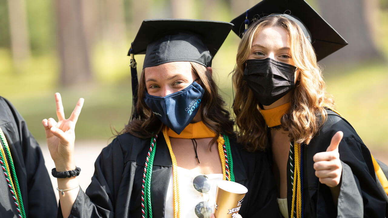 Students posing for camera giving thumbs up