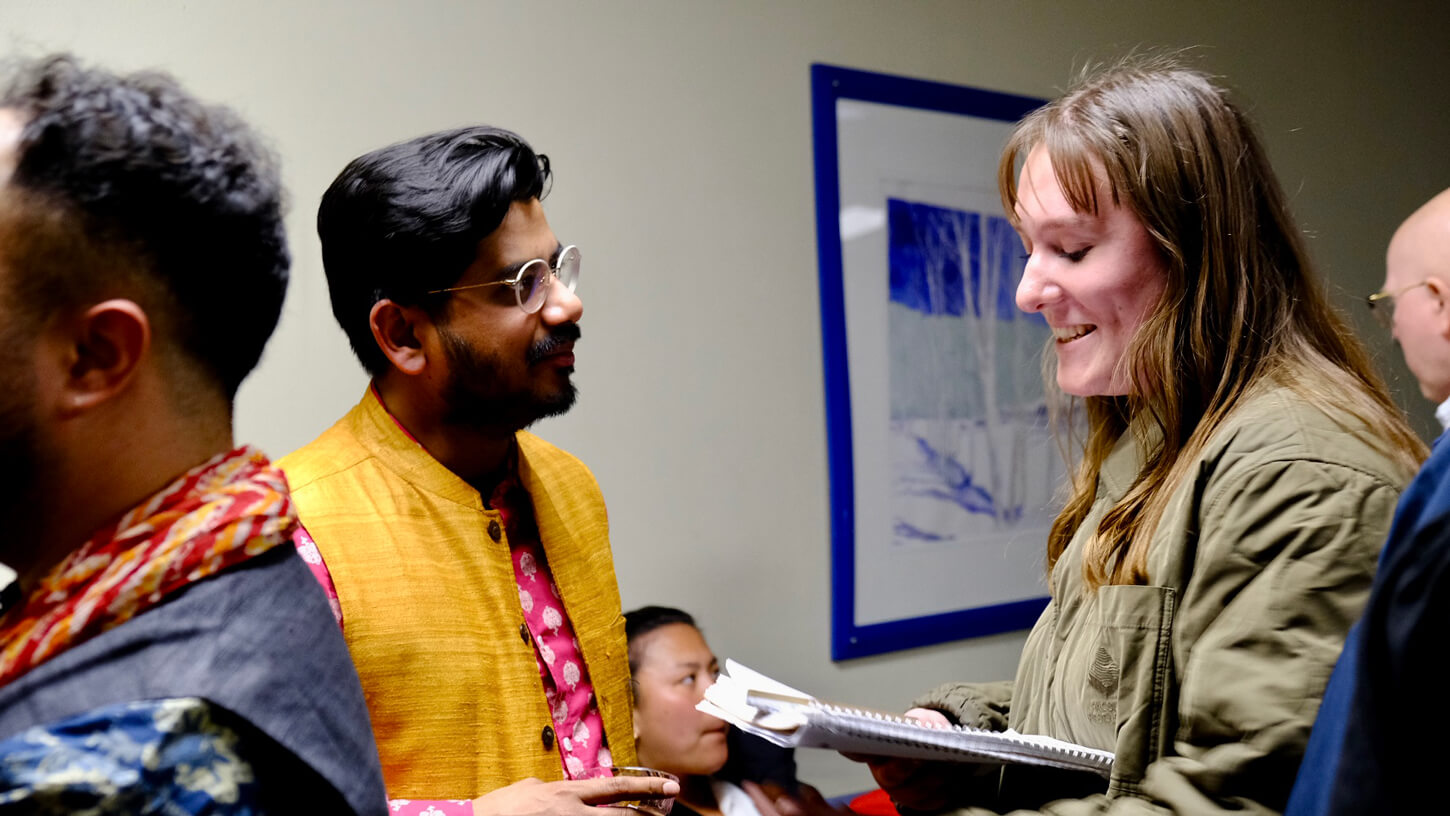 Priya Darshini of Butter Chicken speaks with a student holding a notepad during the reception after the concert.