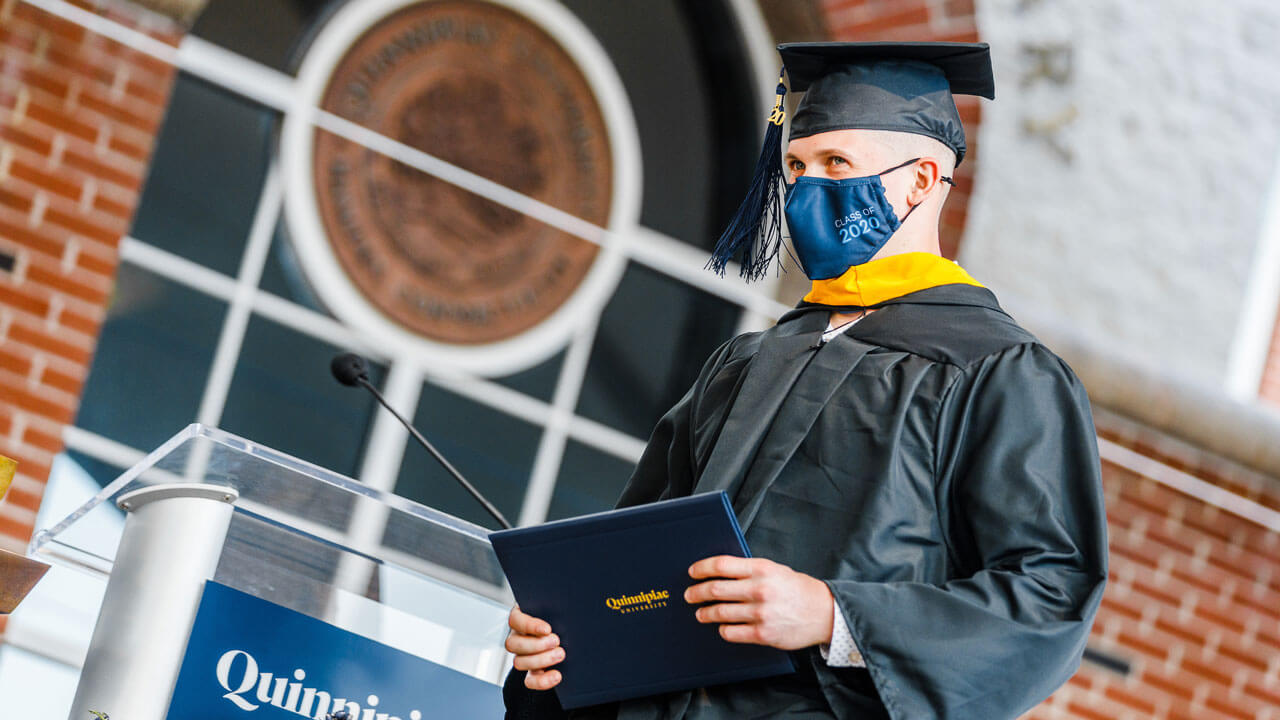 Student walking across the stage carrying their diploma