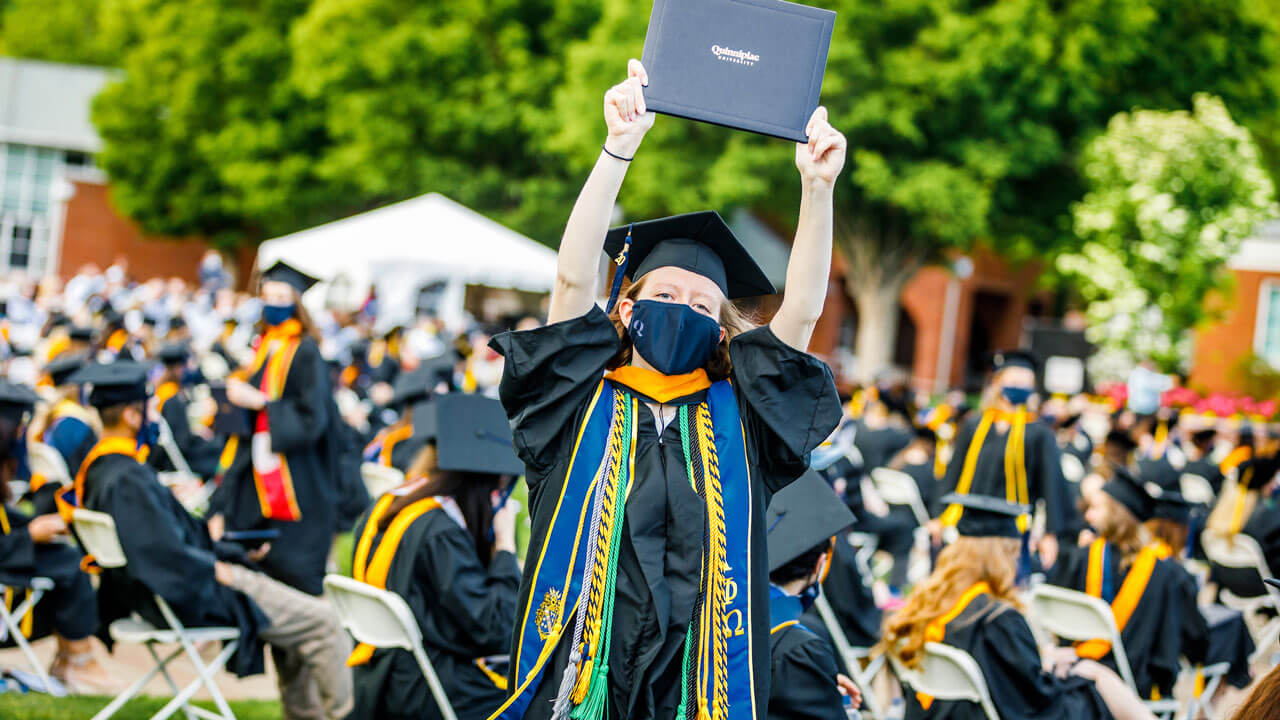 Graduate showcasing her diploma
