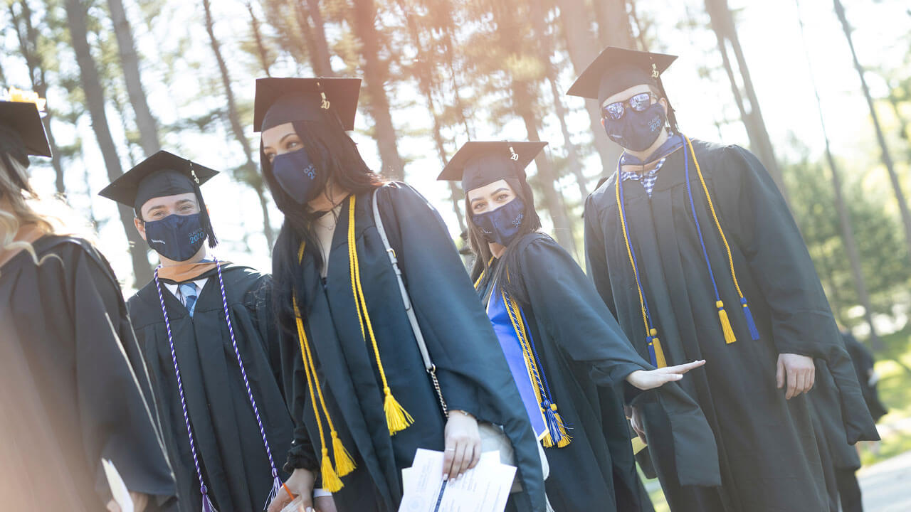 2020 graduates standing in the pine grove before the start of the commencement ceremony