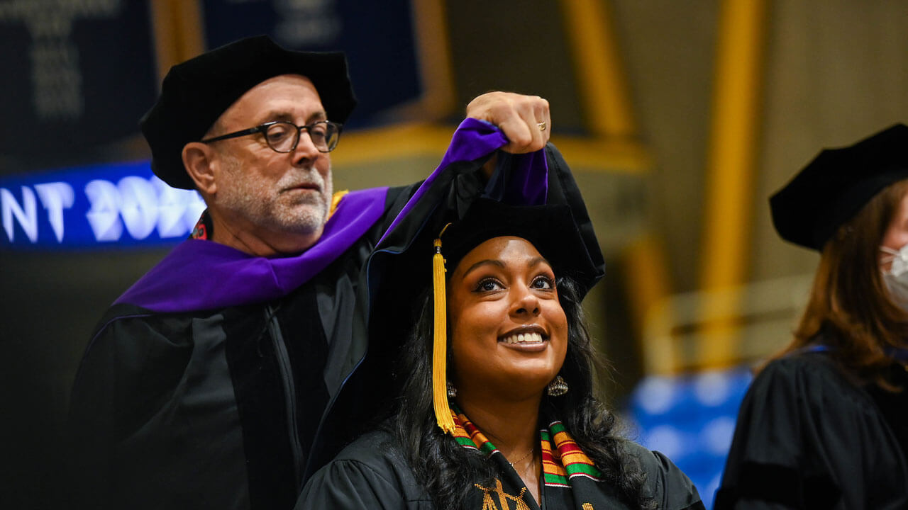 A graduating law student receives her hood