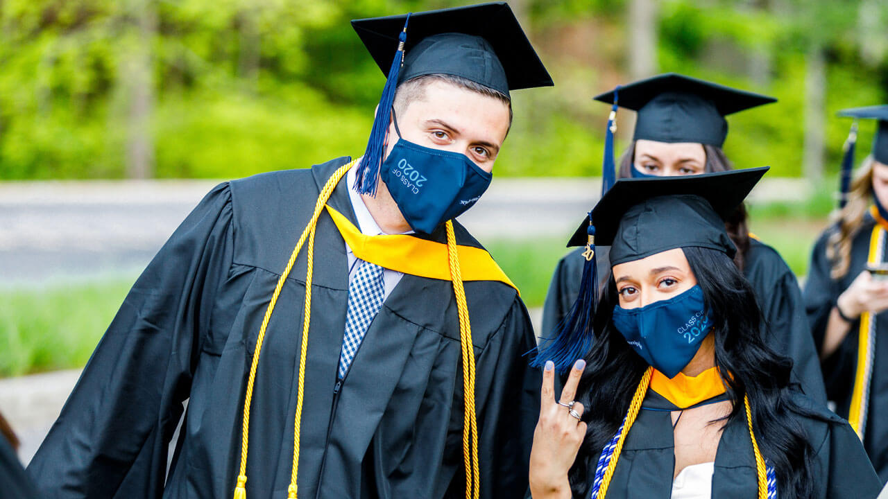 Valon Camaj looking into camera wearing cap and gown