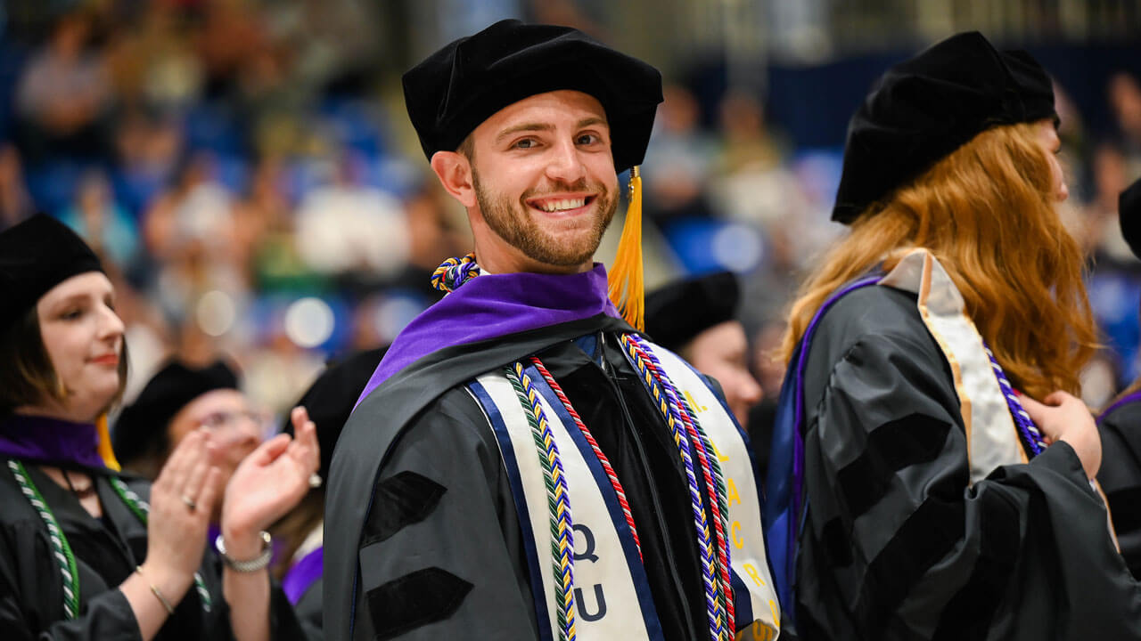A graduating law student smiles for the camera