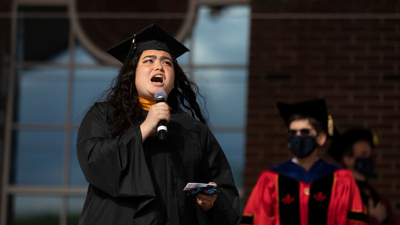 Erin D. Schirra sings with a microphone on the library steps