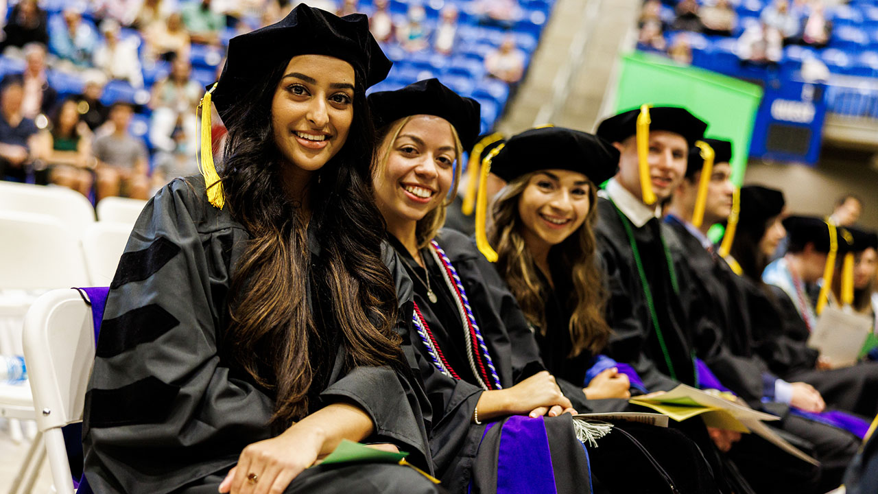 Graduates smile in their seats