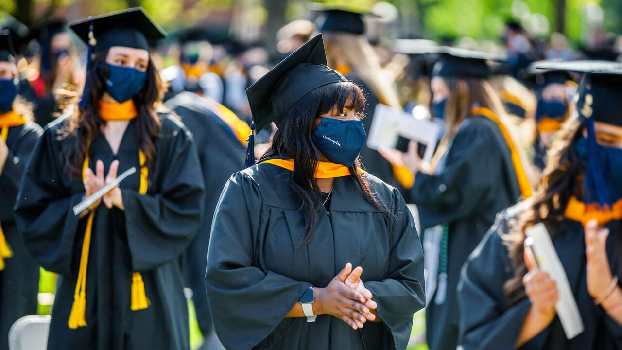 Graduates clapping at commencement ceremony