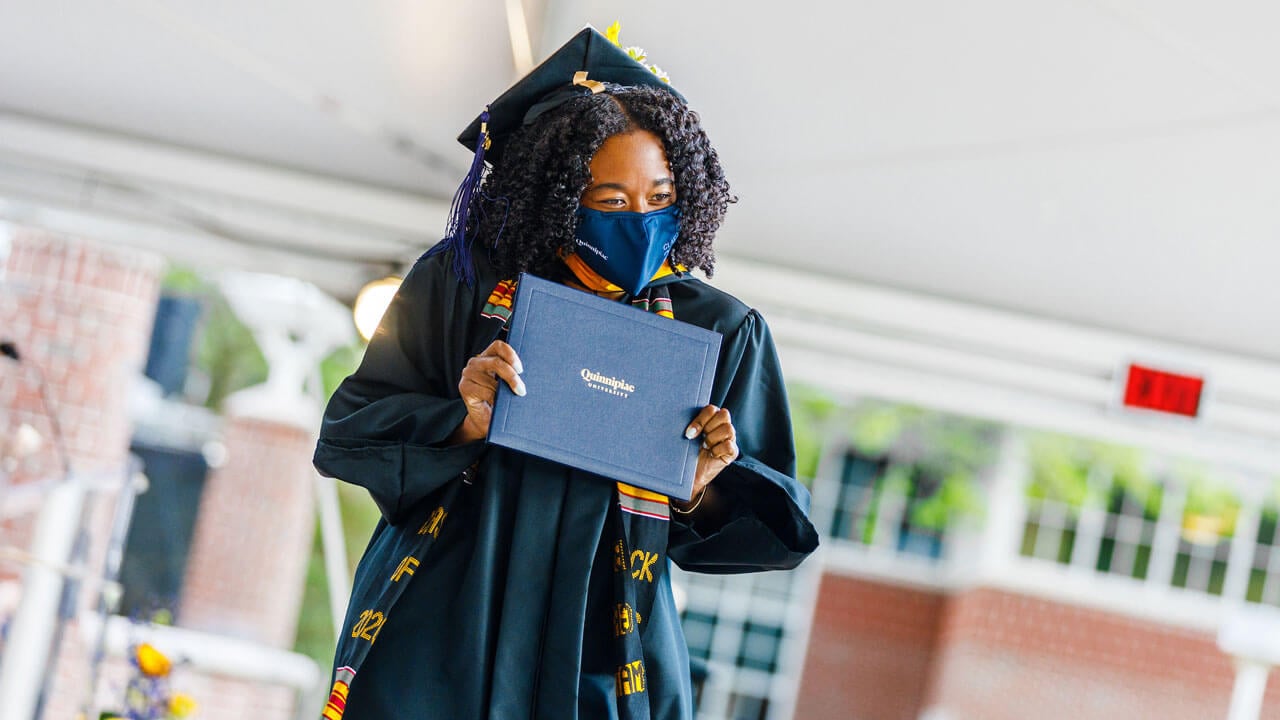 Graduate walking across the stage with her diploma