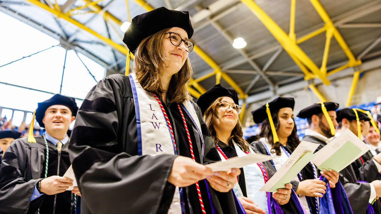A line of graduating law students read their professional oaths out loud during commencement