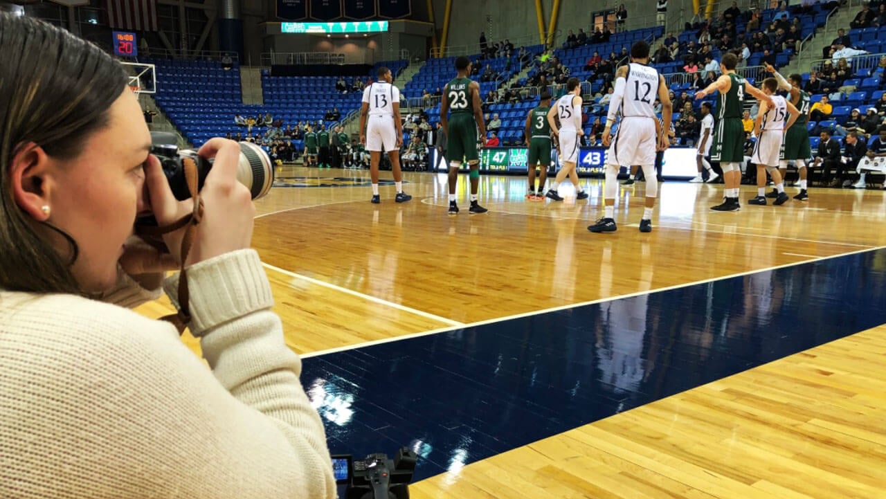 Individual photographs a basketball game.