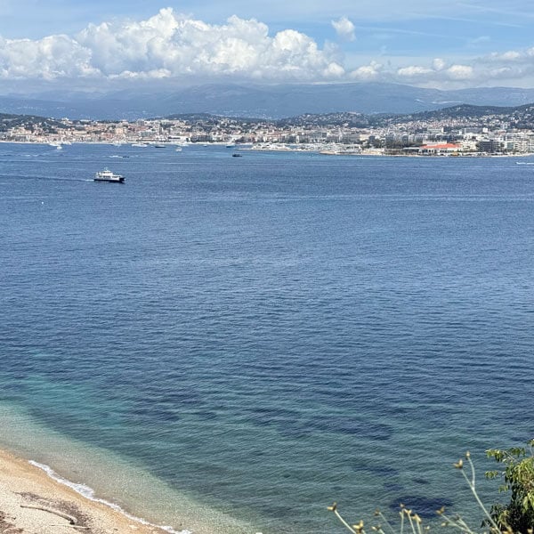 Photo of the ocean with the town of Cannes, France in the background.