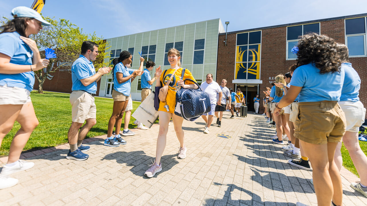 Person walks outside carrying a bag