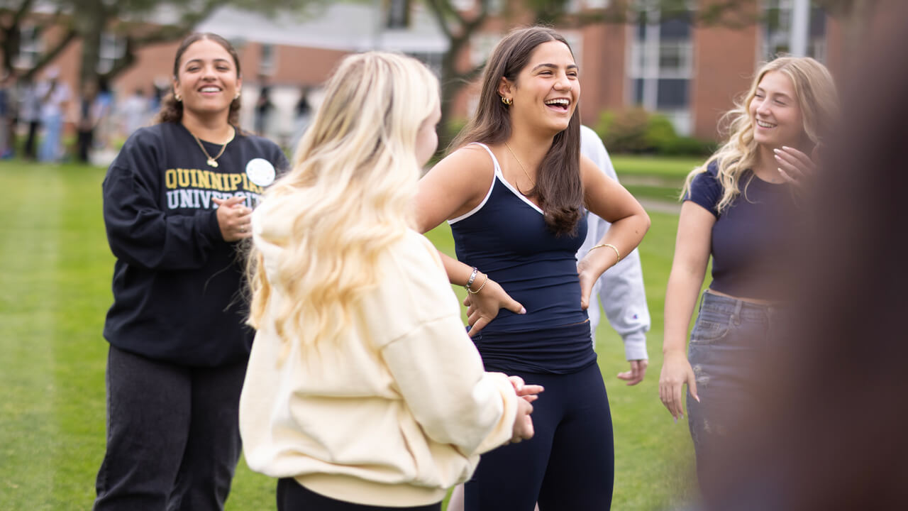 A group of individuals stand and smile during Orientation