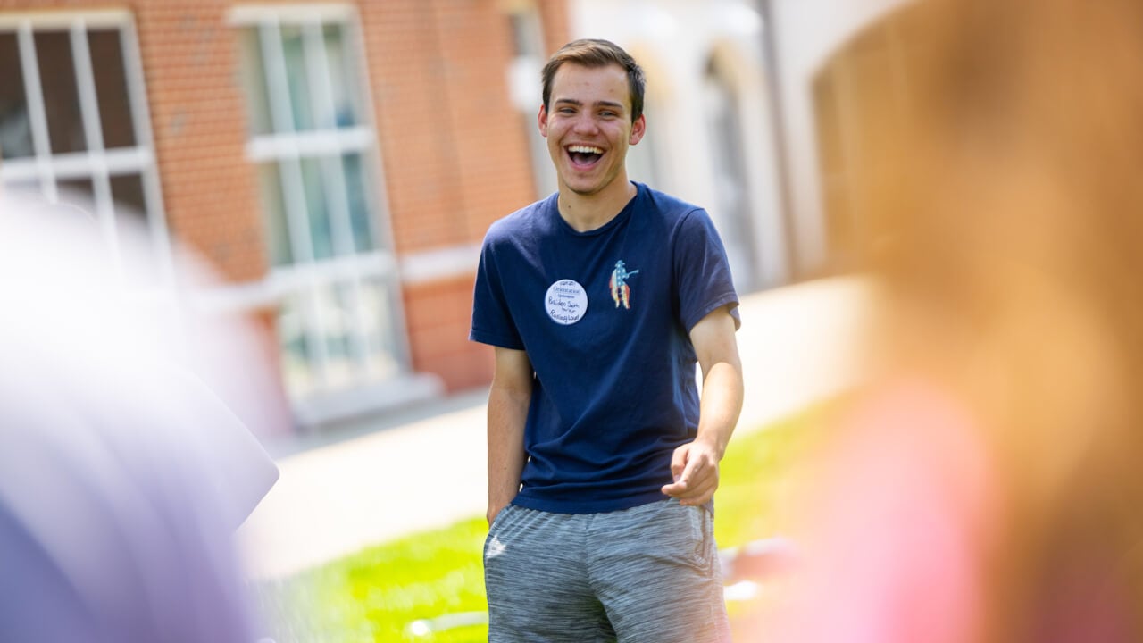 Individual smiling and laughing during Orientation