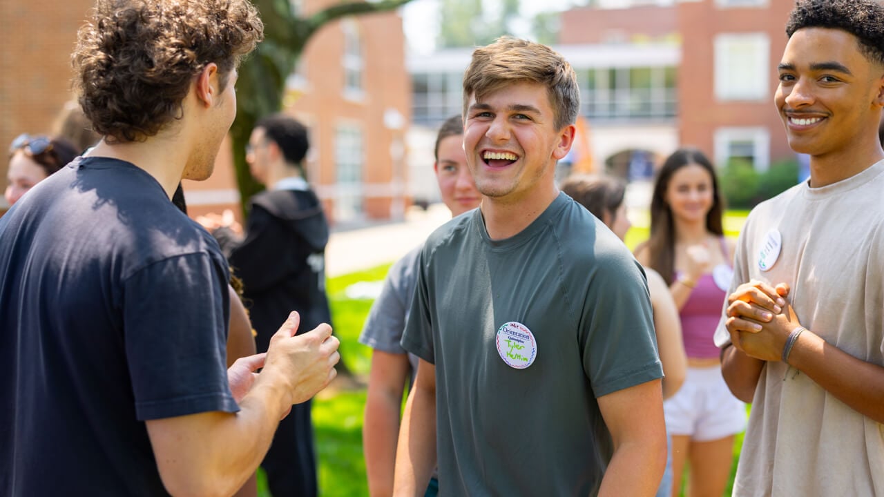 Individual smiling and laughing during Orientation
