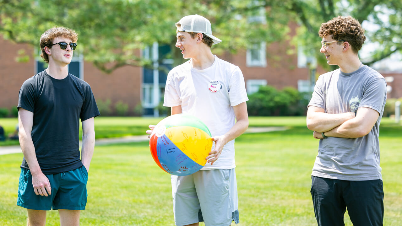 Students talk while holding a beach ball