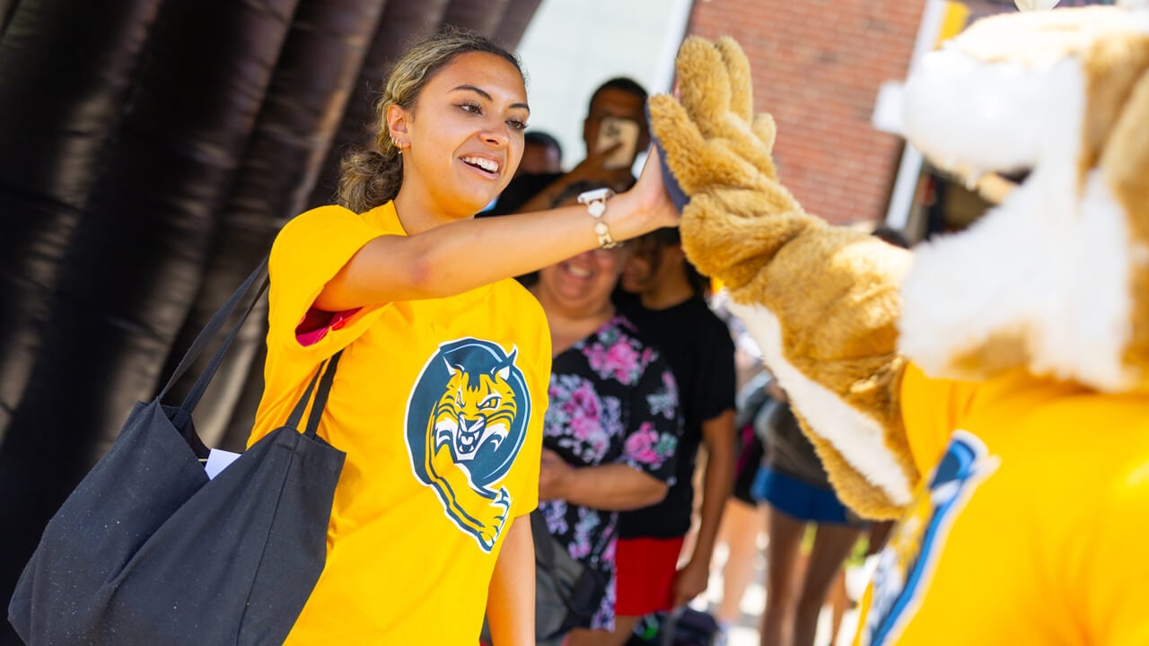 Individual high fives Boomer at Orientation