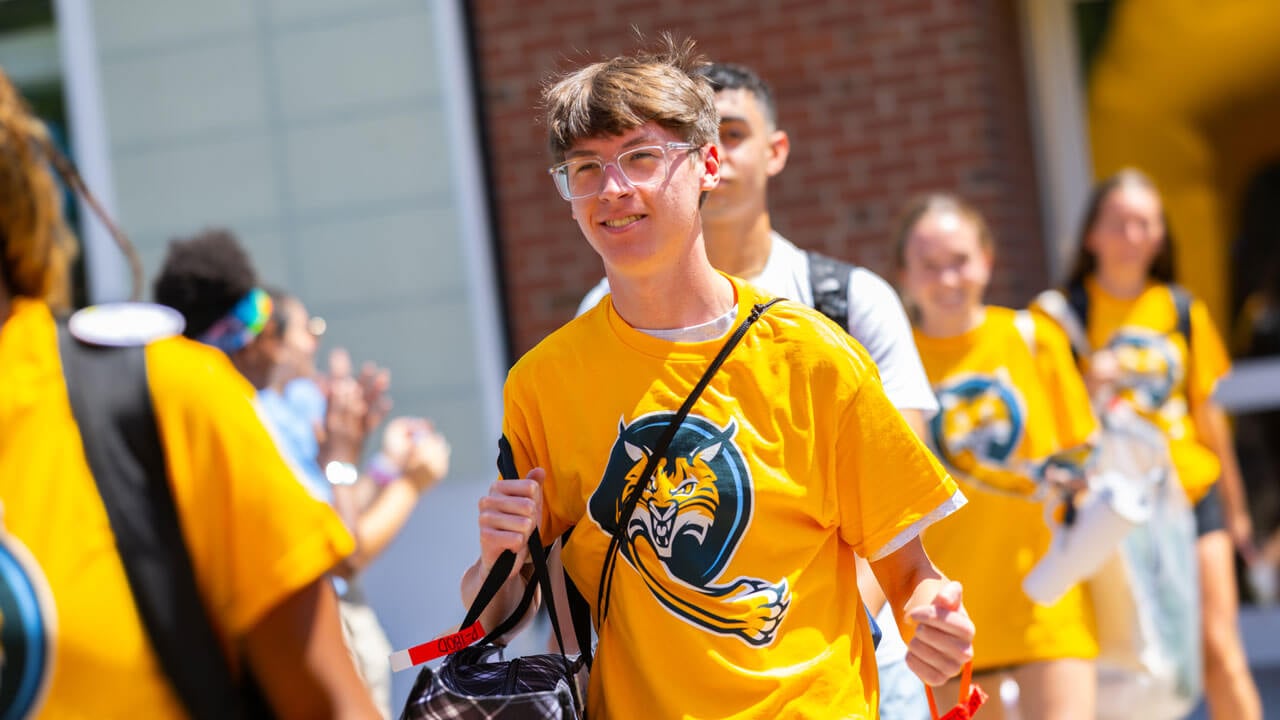 Individual smiles as they walk out of the Recreation and Wellness Center.