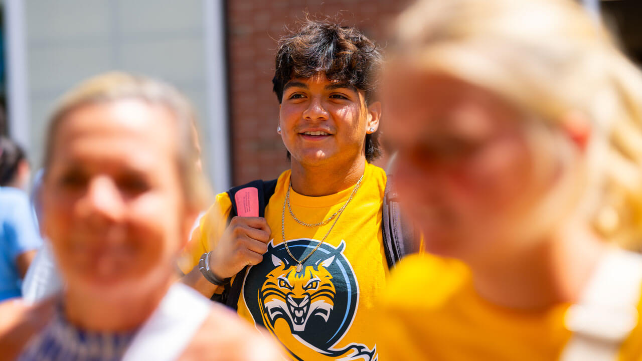 Individual smiles while walking through a crowd.