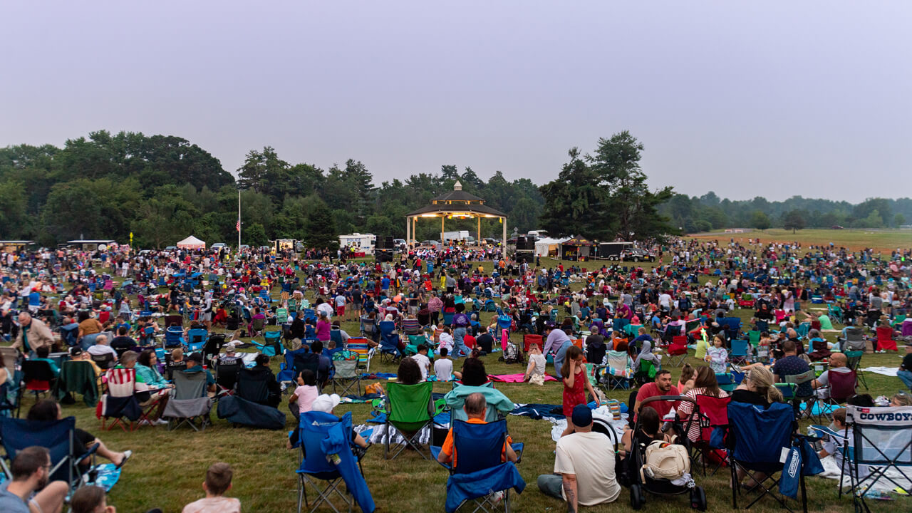 Hundreds of people sit on blankets and chairs on the Hamden town green for 4th of July fireworks