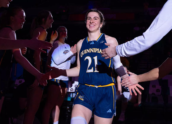 Basketball player receives high fives from teammates.