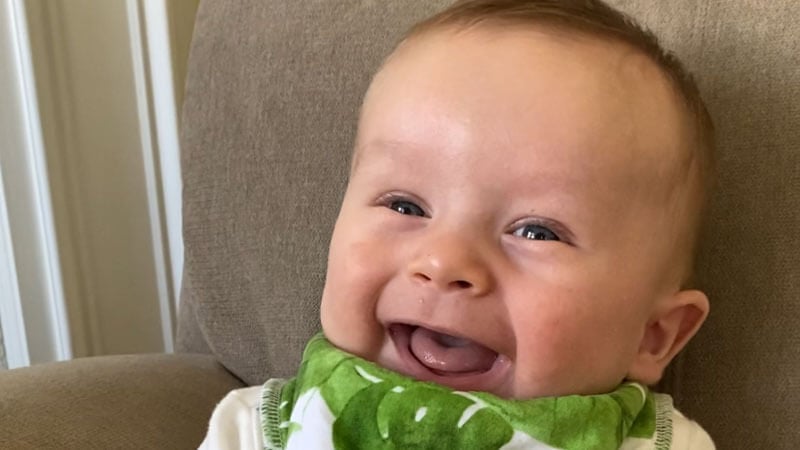 Bohensky baby giggles as he sits in a chair