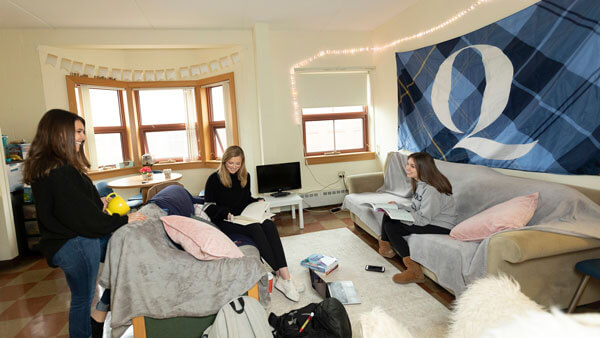 Girls sitting in a common room working on homework
