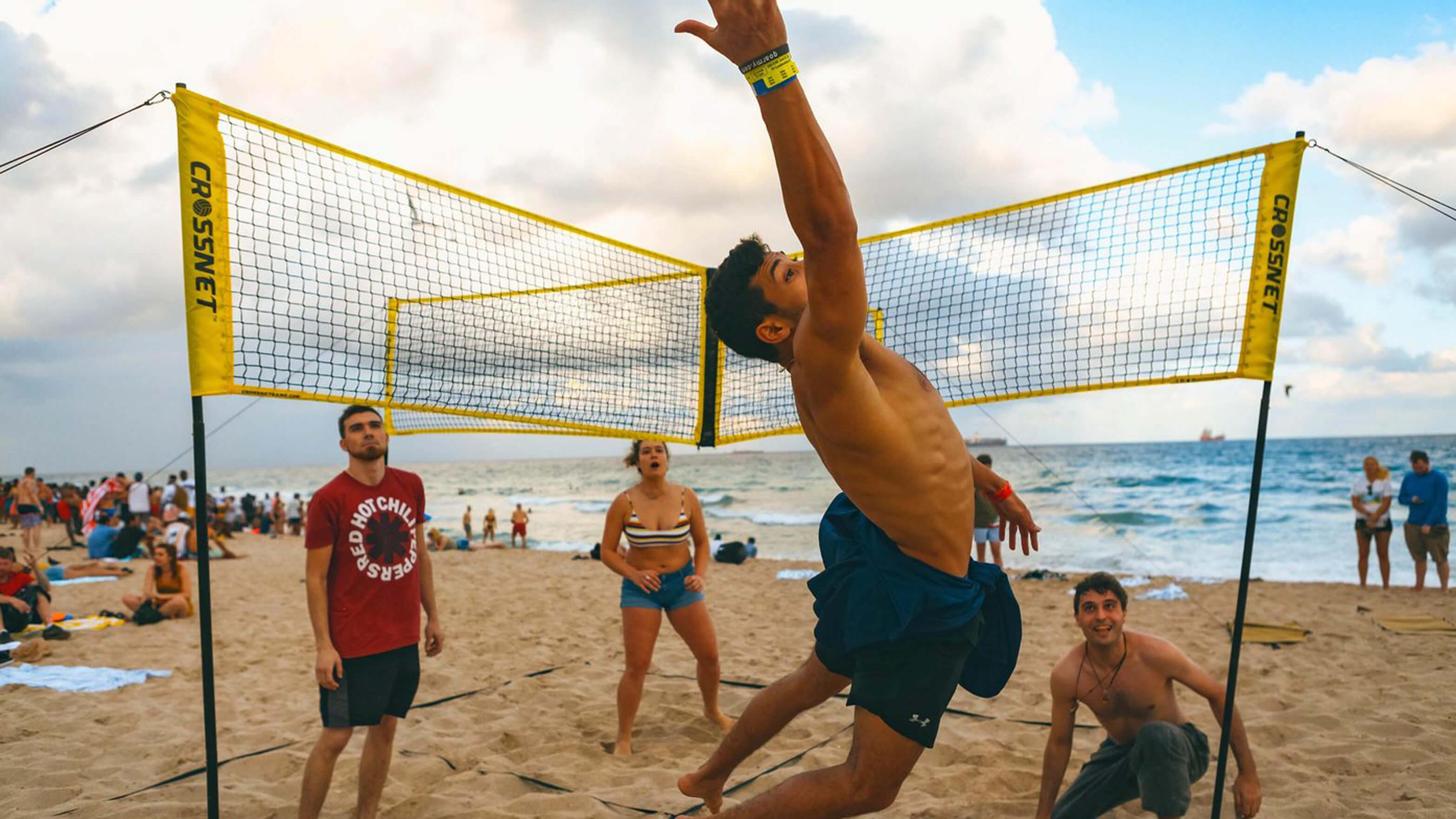 An action shot of four people using CROSSNET on the beach
