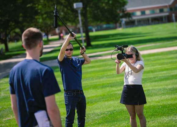 Individuals filming a video on the Quad