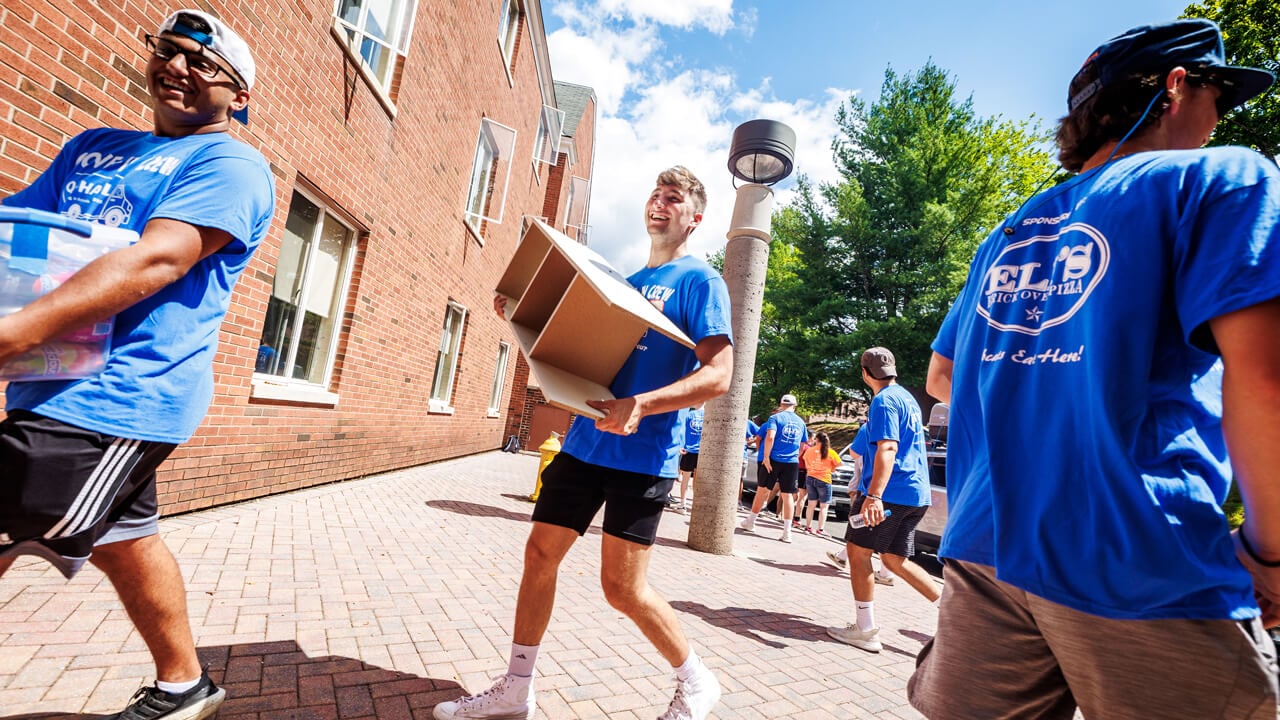 Individuals carrying boxes during move-in