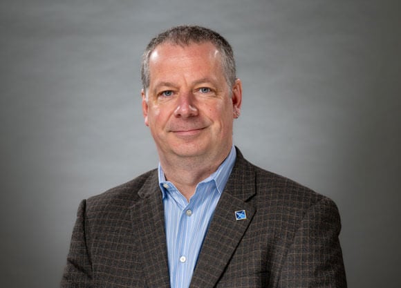 Alexander Laskin sitting against a grey background