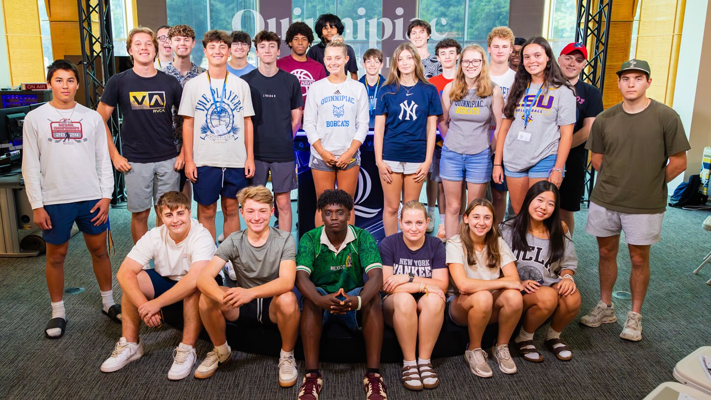 Diverse group of high school students gathered and smiling inside Quinnipiac University’s open-air studio during the Movie Making Summer Camp.