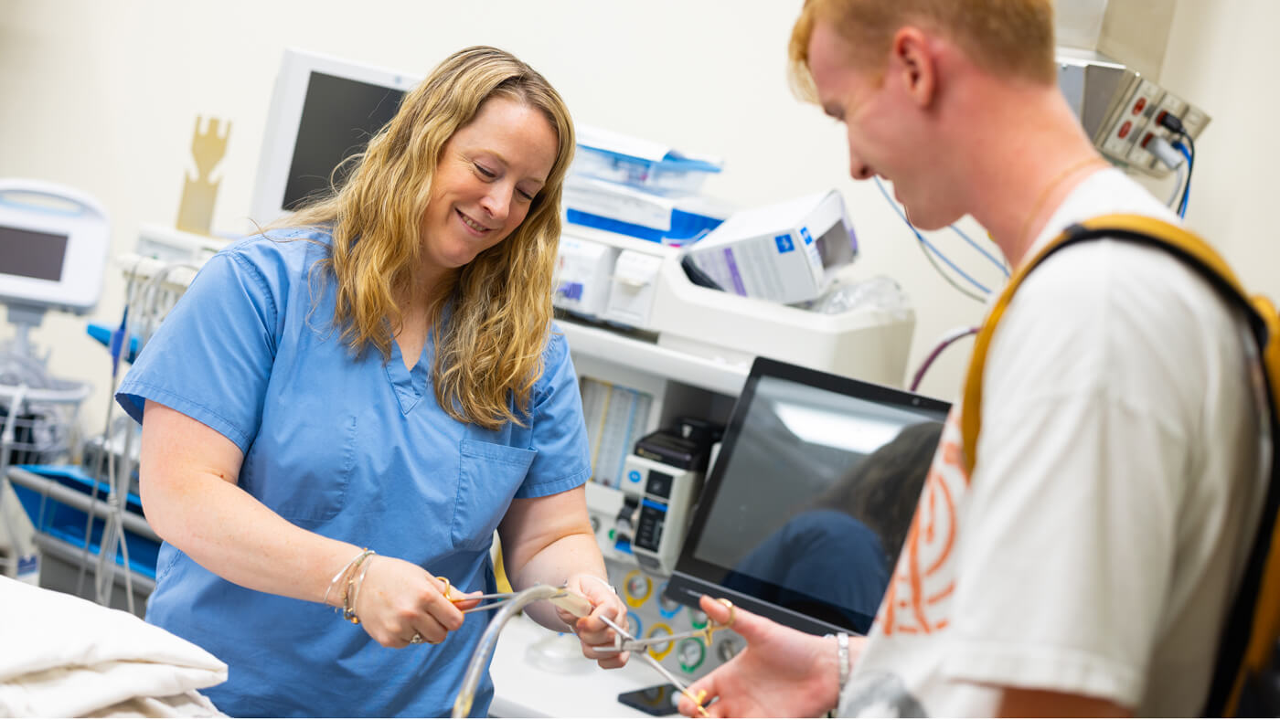 Quinnipiac professor gives high school student a demonstration using professional medical equipment.