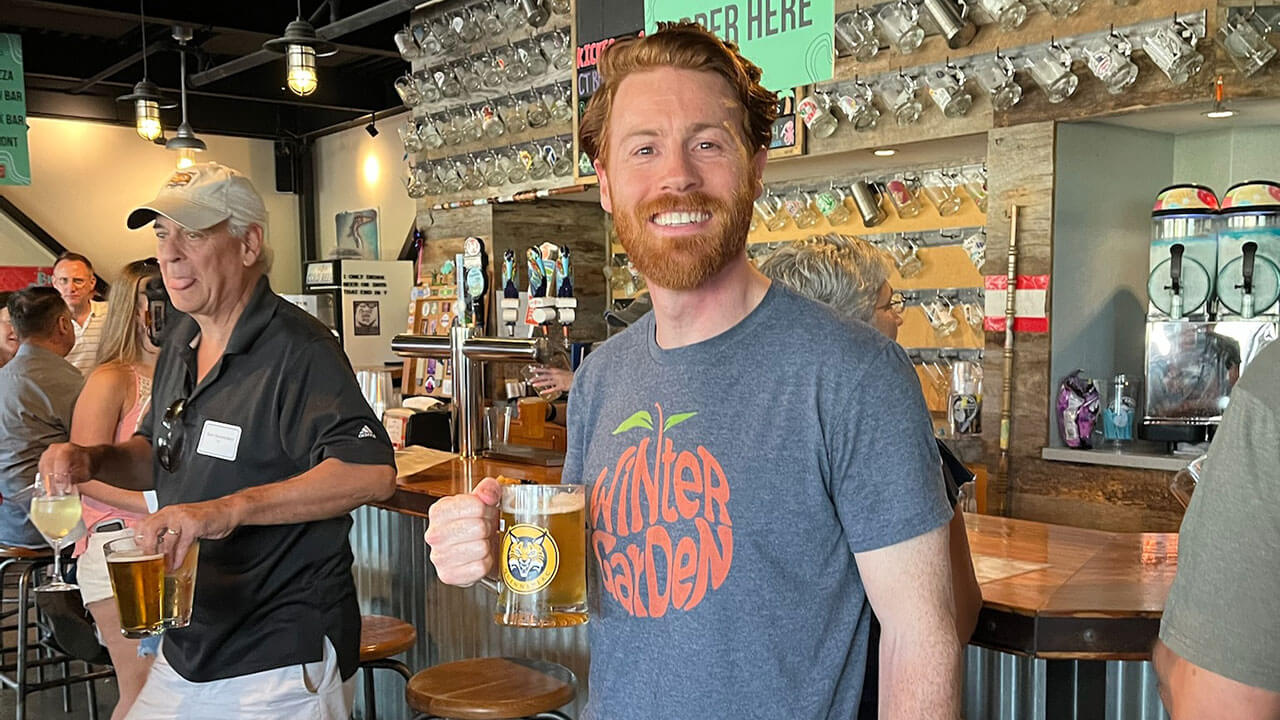 A Quinnipiac alum drinks out of a Bobcat branded glass