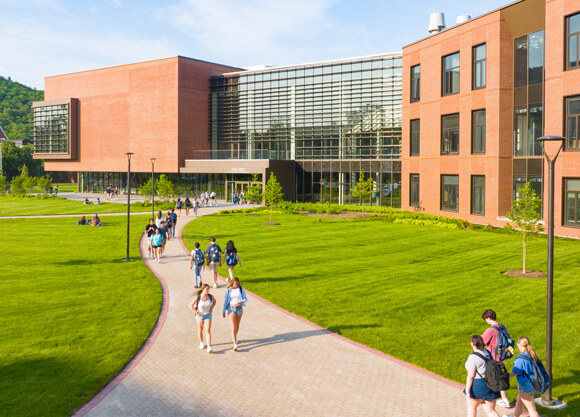 Students walk along the paths in front of the Quinnipiac School of Business on the South Quad