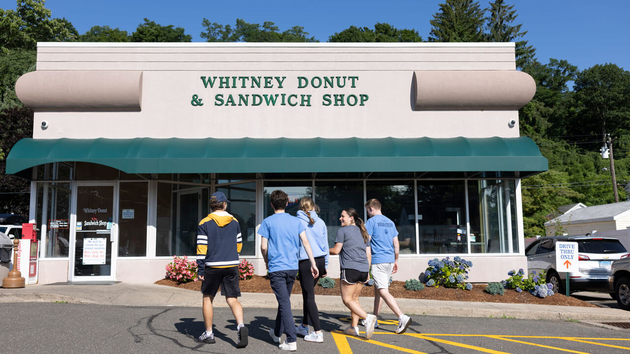 A group of friends walk into Whitney Donut Sandwich Shop & Sandwich Shop