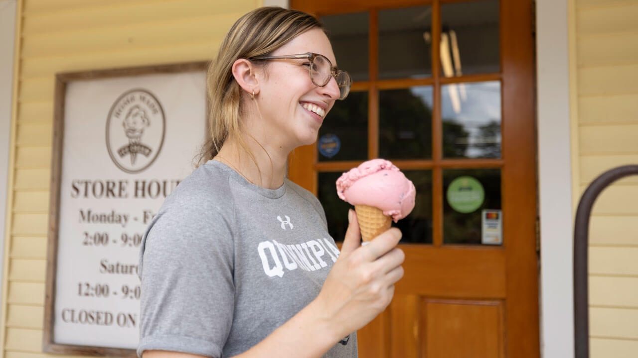 Student smiles with an ice cream cone in her hand