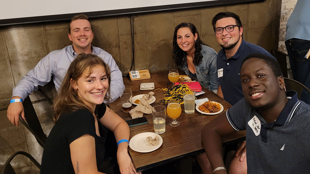 Five alumni smile with excitement while in Boston