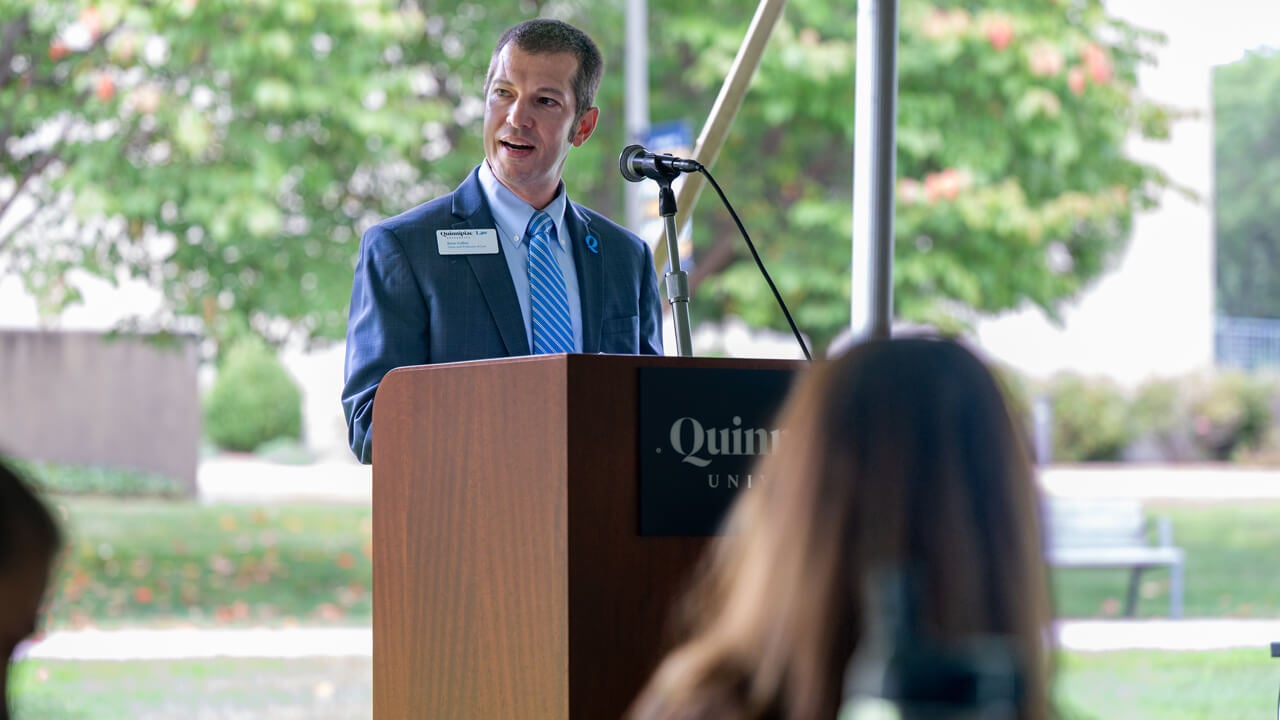 Person speaking at a podium outside
