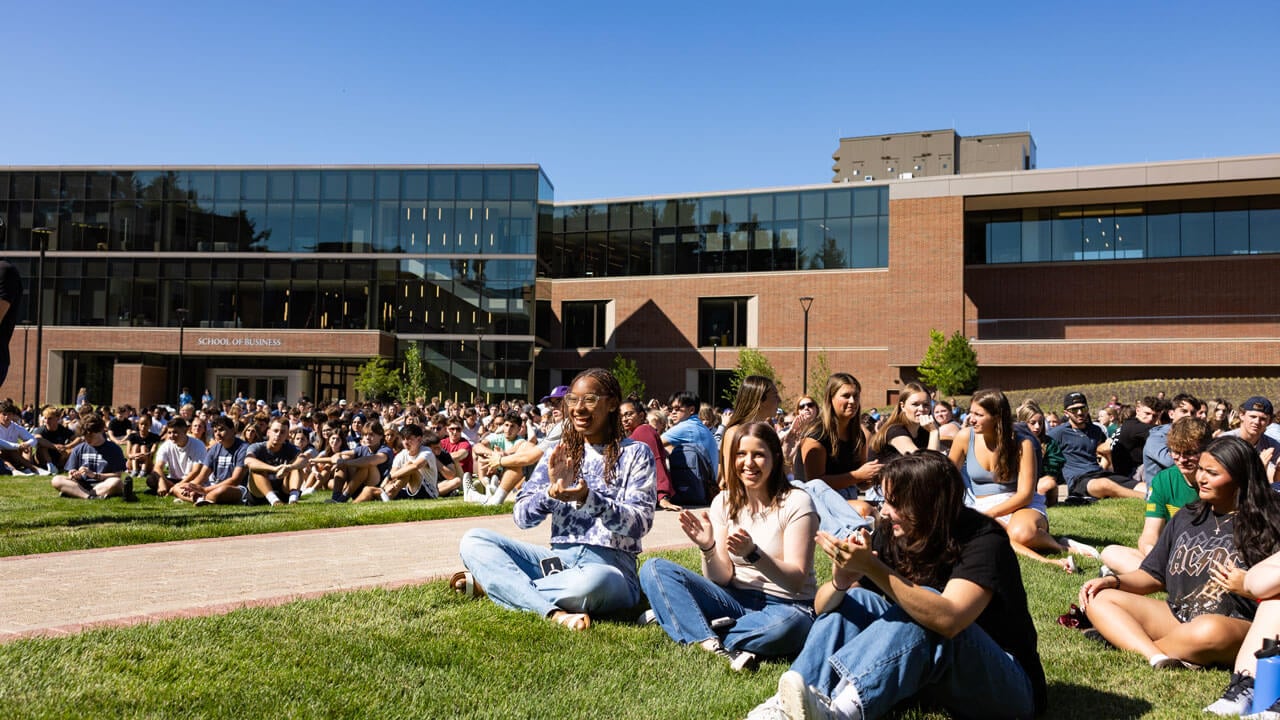Students clap sitting on South Quad