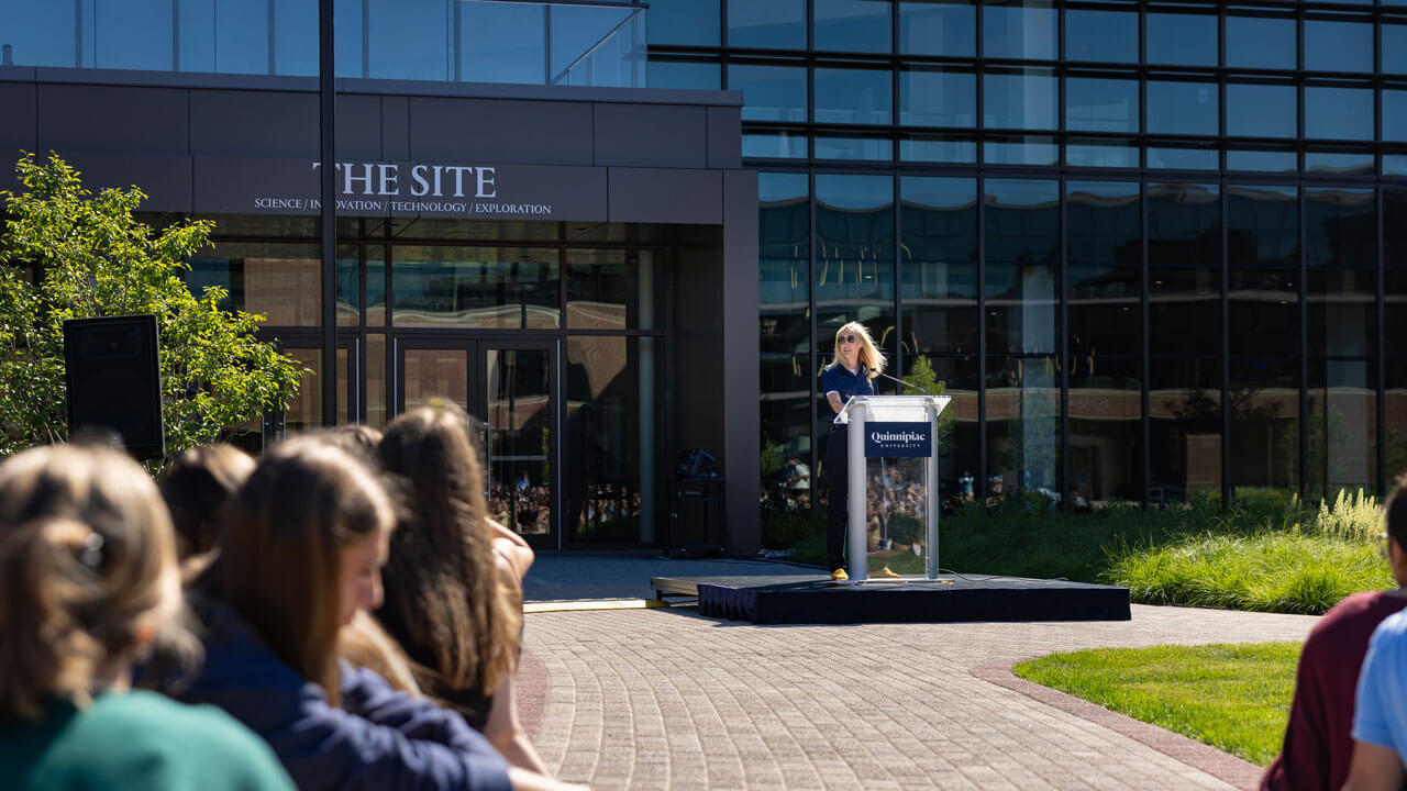 President Marie Hardin standing at the podium talking to students