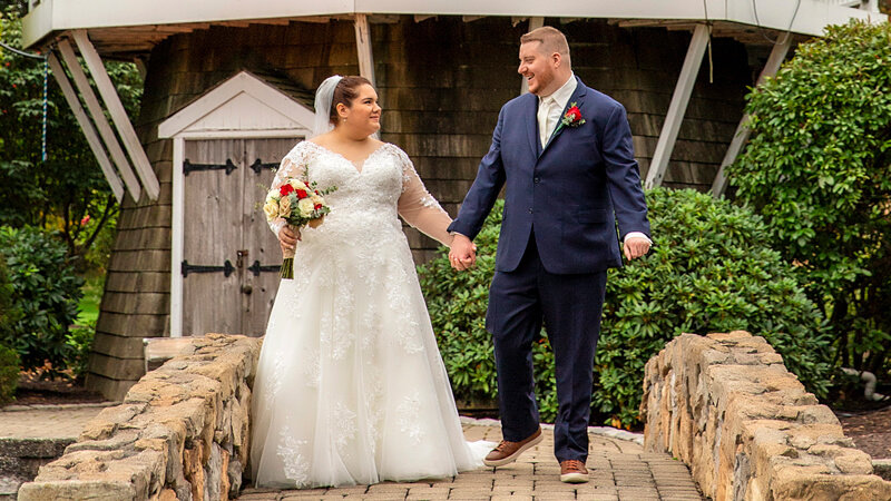 Lauren Klein and Joseph Durso hold hands in front of a windmill on their wedding day