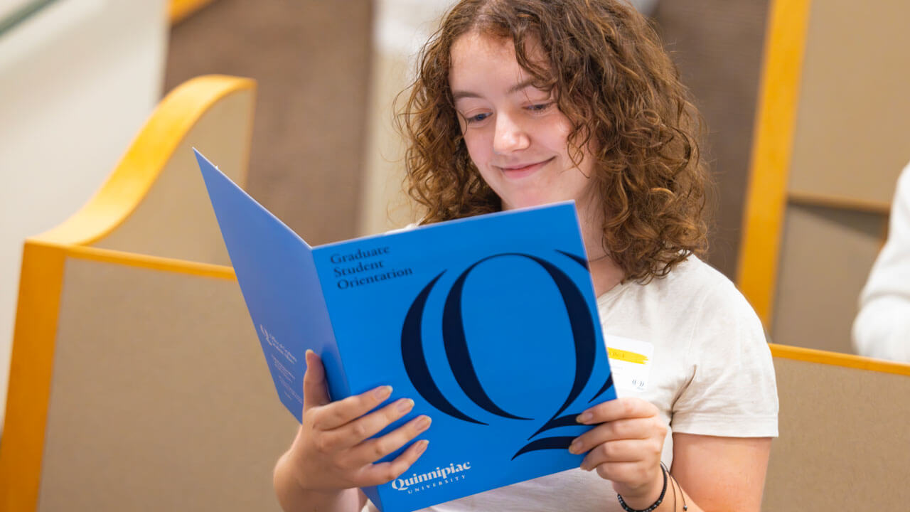 Graduate student reads an informational pamphlet.