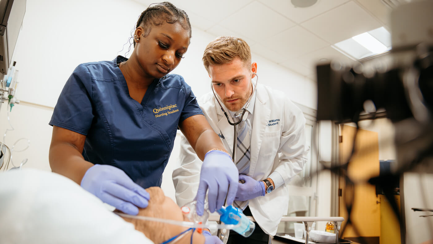 Nursing students use medical-grade tools to address their manikin patient's needs.