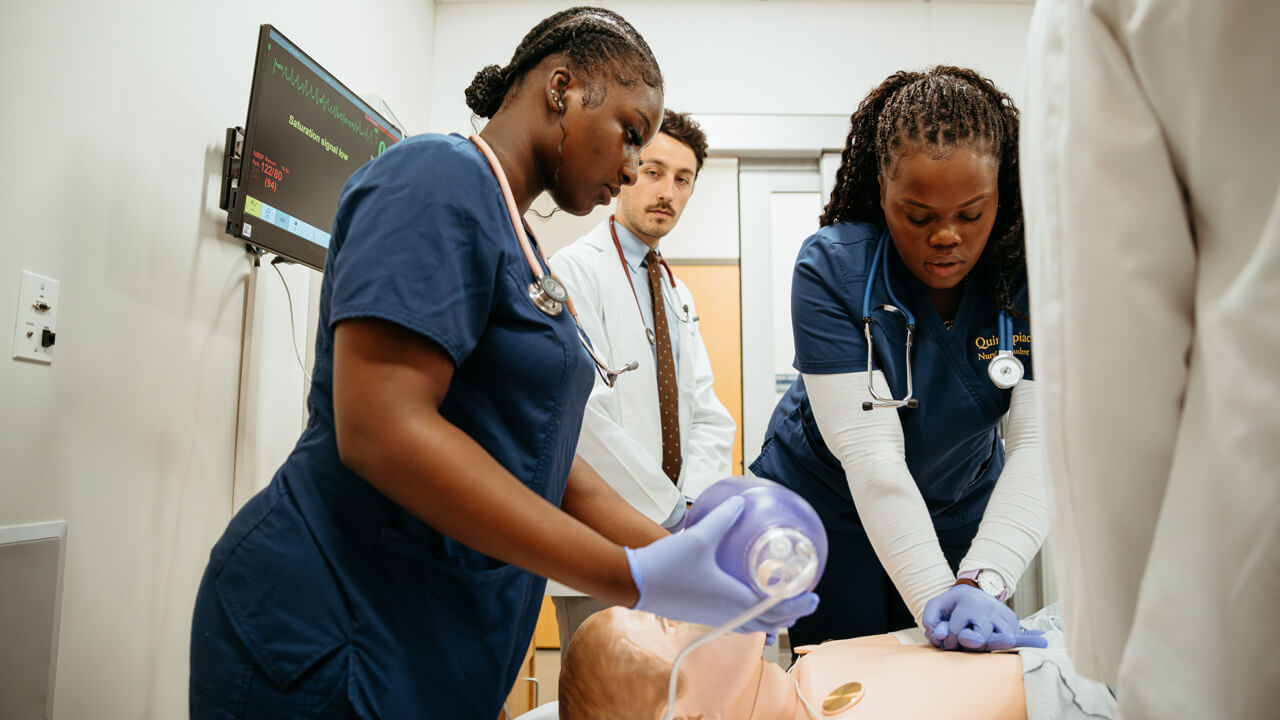 Quinnipiac nursing students perform CPR on a manikin patient in the simulation suite.