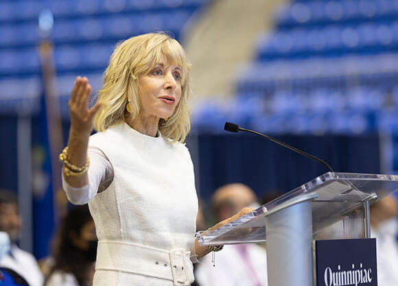 Quinnipiac President Judy Olian speaks from a podium