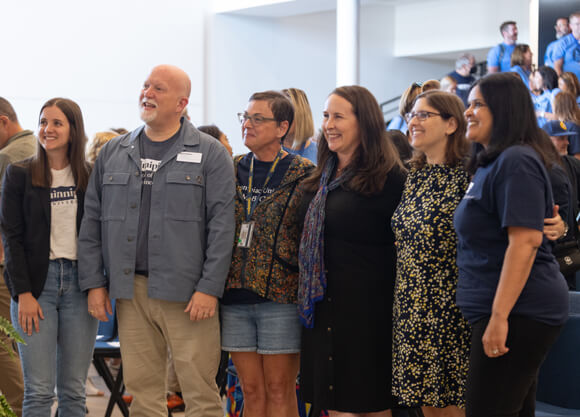 The 2025 Center for Excellence Honorees stand arm in arm in The SITE auditorium