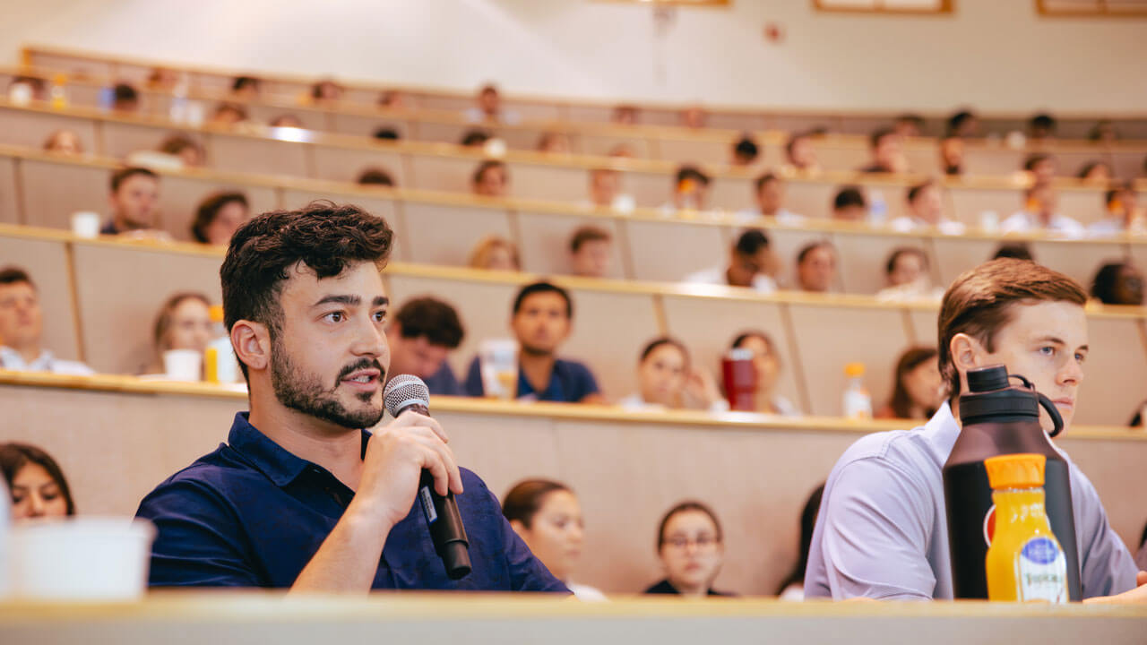 Grad student holds a microphone to ask a question